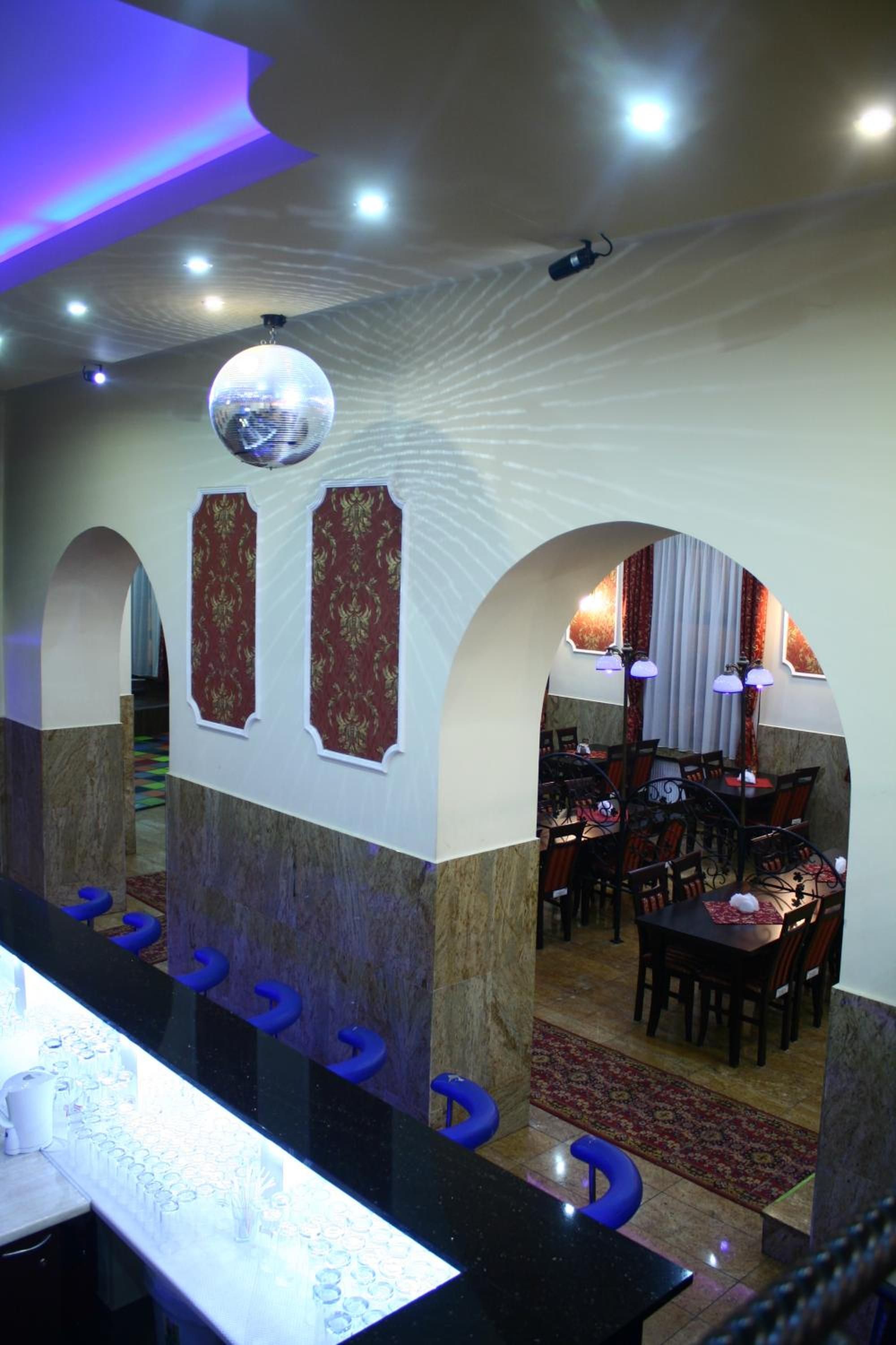A restaurant interior with a bar area, seating, and decorative wall panels.
