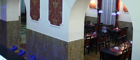 A restaurant interior with a bar area, seating, and decorative wall panels.