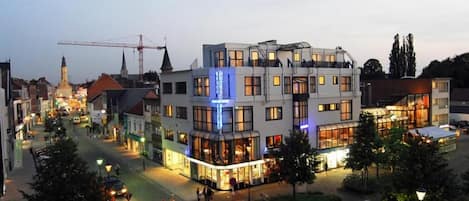 A multi-story hotel with a modern design, featuring a glass facade and a courtyard.