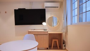 A room with a desk, chair, round mirror, and a TV mounted on the wall. - Ace Hotel By Cozy Daejeon Yuseong Branch (Daejeon)