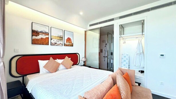 Une chambre d’hôtel moderne équipée d’un lit, d’un canapé, d’une douche et d’une armoire.