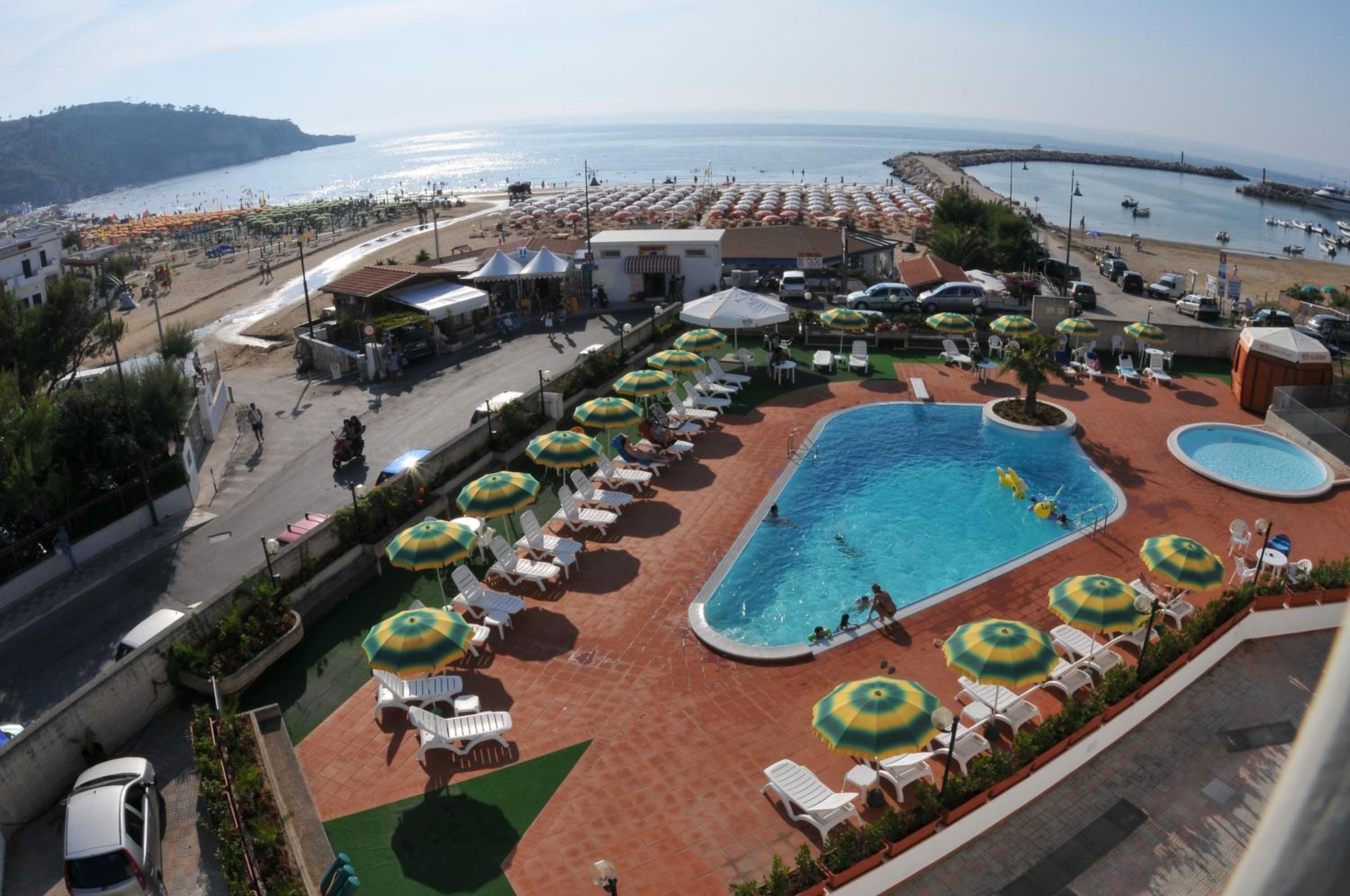 A resort with a swimming pool, sun loungers, and umbrellas.