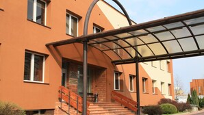 A building with a covered entrance, a staircase, and a sign indicating a medical center. - Centrum Konferencyjne Ibib Pan (Warsaw)
