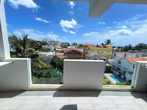 Ein Balkon mit Blick auf eine Wohngegend, darunter Gebäude und ein Schwimmbecken.