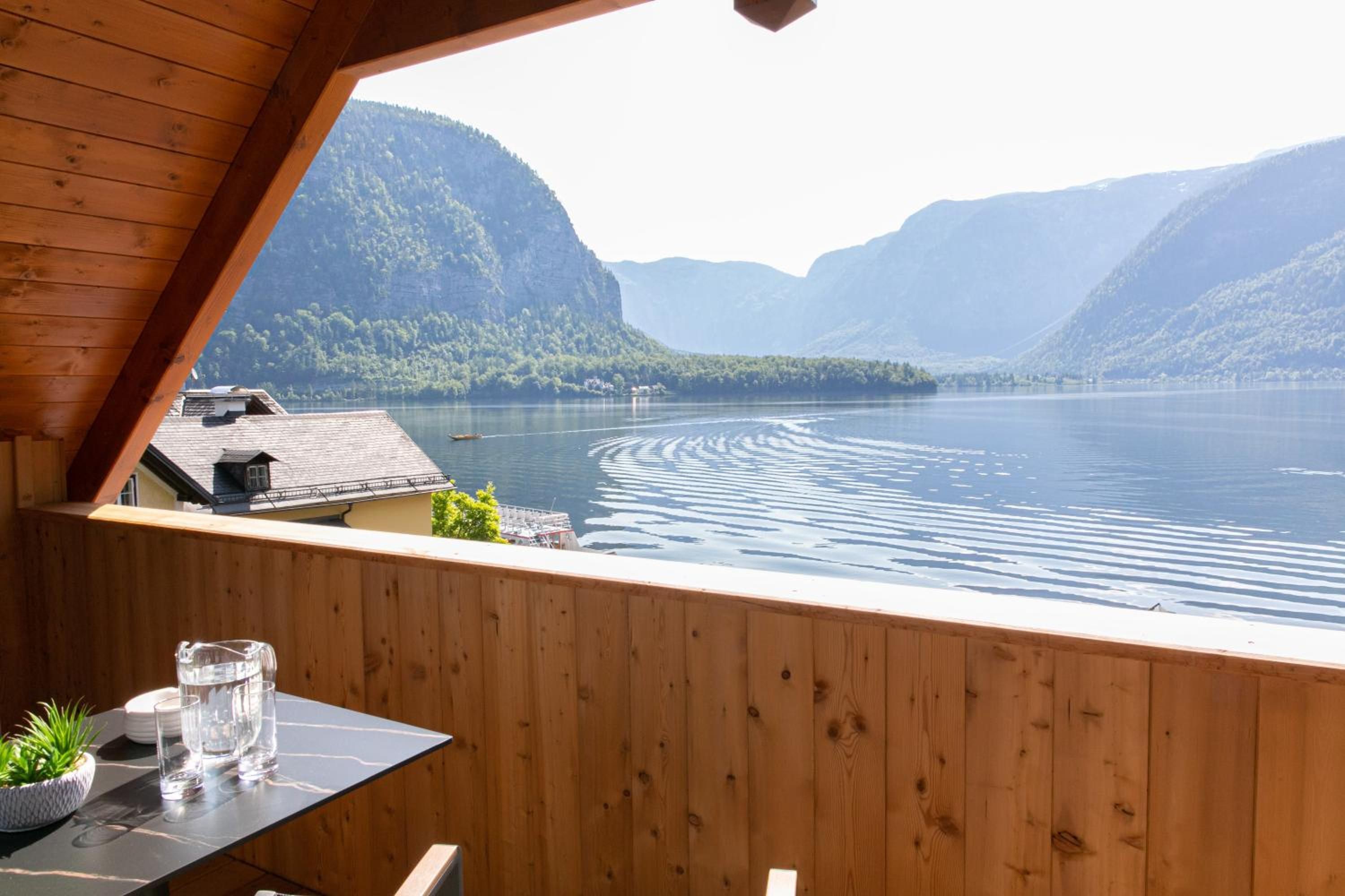A wooden cabin with a view of a lake and mountains.