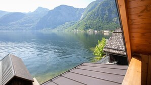 A wooden cabin with a view of a calm lake and mountains. - Weisses Lamm (Hallstatt)