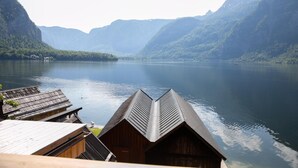 A lakeside view with wooden cabins and a mountain backdrop. - Weisses Lamm (Hallstatt)