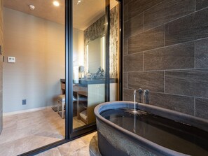 A modern bathroom with a freestanding bathtub, a glass shower enclosure, and a vanity with a mirror. - Shikinoirodori Hatago (Kobe)