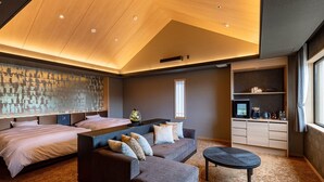 A modern hotel room with a large bed, a sofa, a coffee table, and a kitchen area. - Shikinoirodori Hatago (Kobe)