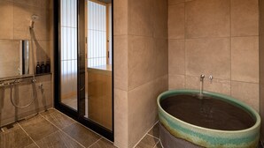 A modern bathroom with a glass shower enclosure, a bathtub, and a visible window. - Shikinoirodori Hatago (Kobe)