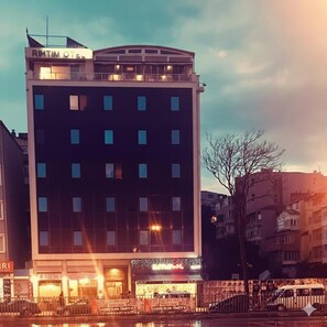 Un edificio de varios pisos con un cartel que dice 'RIHTIM OTEI' en la parte superior.