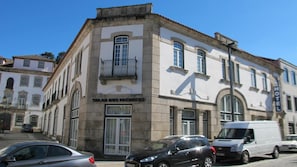 Un edificio con cartel de 'Solar dos Pachecos' hotel, que presenta una fachada tradicional con un balcón y ventanas grandes.