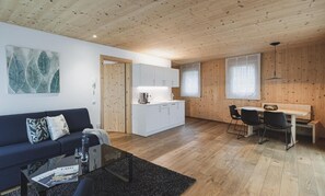 Un espace de vie moderne comprenant un canapé, une table basse et un coin repas avec des chaises et une table.