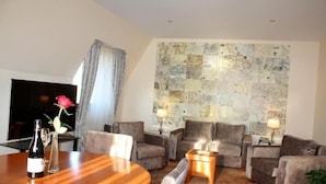 A living room with a large wall map, a wooden dining table with chairs, and a sofa set. - Hotel Park Central (Sliven)