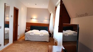 A hotel room with a large bed, a wooden headboard, a mirror, and a wall-mounted light fixture. - Hotel Park Central (Sliven)