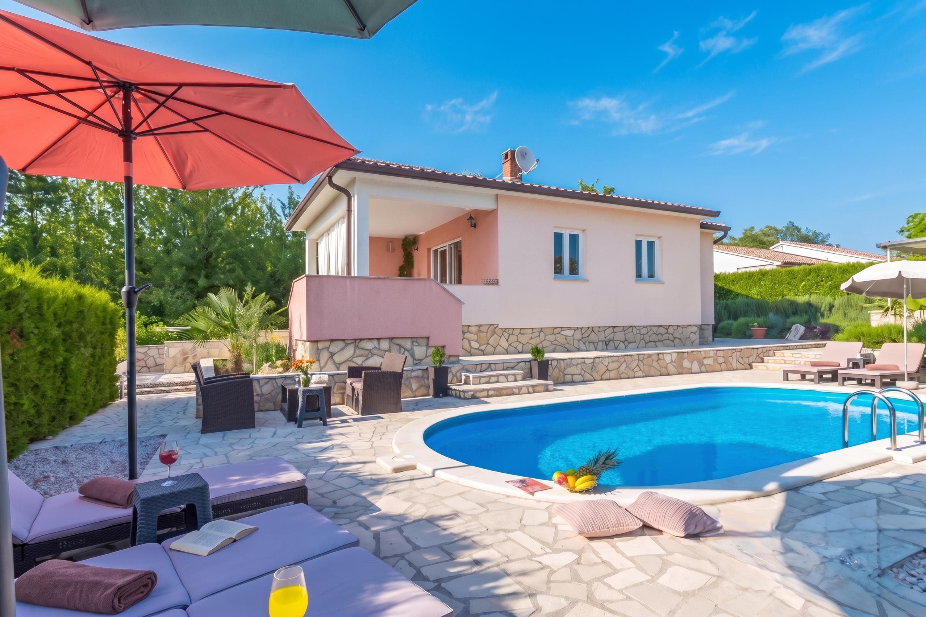 A poolside area with lounge chairs, a red umbrella, and a stone-tiled deck.