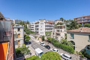 A residential area with multi-story buildings, a street with parked cars, and a clear blue sky. - Lion Apt - Near City Center - Terrace, Nice, France (Nice)