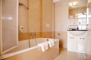 Un baño moderno con bañera, ducha y lavamanos.