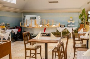A restaurant with a food truck, tables with white tablecloths, and chairs. - Hotel Du Faucon (Fribourg)