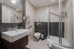 A modern bathroom with a large sink, toilet, and shower area. - Hotel Polo (Prešov)