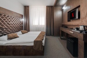 A hotel room with a bed, a desk, a television, and a coffee maker. - Hotel Polo (Prešov)