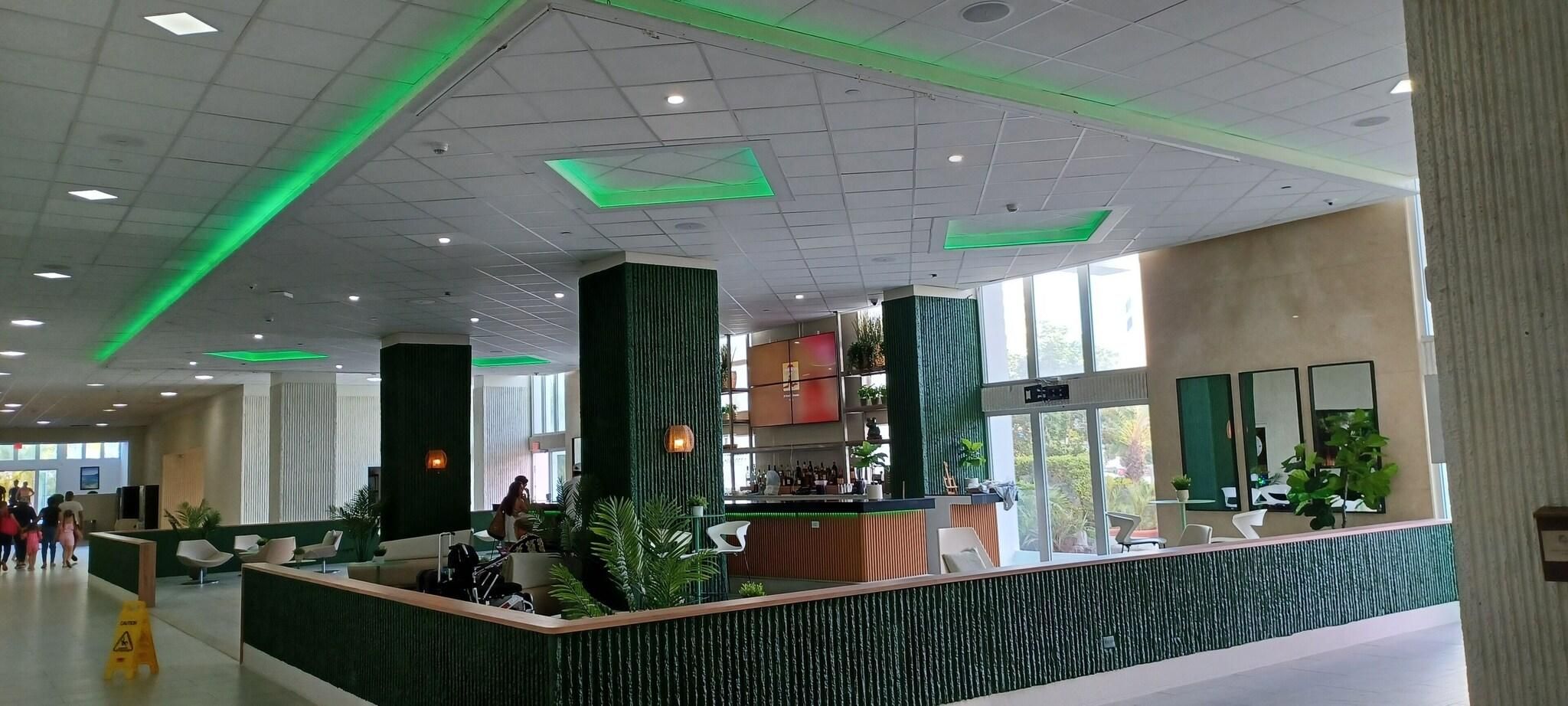 Un hall amplio con mostrador de recepción, zonas de estar y grandes ventanales que dejan entrar la luz natural.