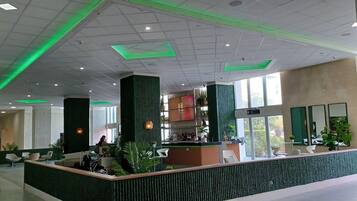 Un hall amplio con mostrador de recepción, zonas de estar y grandes ventanales que dejan entrar la luz natural.