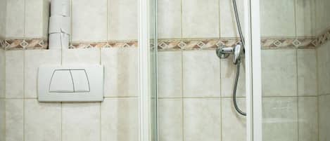 A bathroom with a toilet, a shower enclosure, and a bathtub.