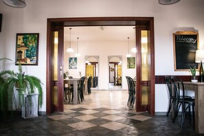 A hotel lobby with a checkered floor, multiple dining areas, and a chalkboard with 'PoloCamy' written on it. - Hotel Ach To Tu (gmina Święciechowa)