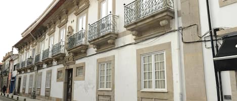 A building with multiple windows and balconies, featuring classical architectural elements.