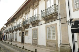 A building with multiple windows and balconies, featuring classical architectural elements.
