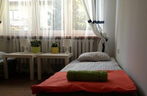 A room with a bed, two bedside tables, two lamps, and two potted plants. - Place4us (Warsaw)