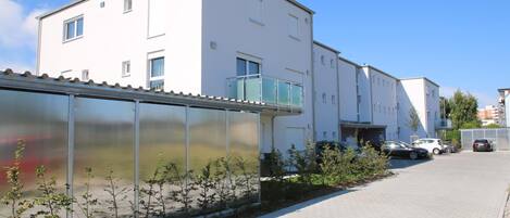 Un edificio moderno con techo plano, amplios ventanales y acceso mediante portón.