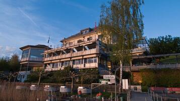 A multi-story building with a dock and a boat named 'Delphin' in the foreground.