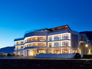 A multi-story hotel with balconies, large windows, and a modern architectural design. - Sonja Alpine Resort (Piesendorf)