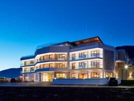 Um hotel com vários andares, varandas, janelas amplas e um design arquitetônico moderno.