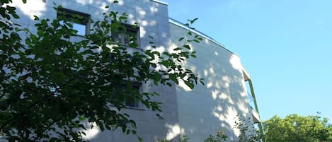 A modern building with a curved facade, large windows, and a door.