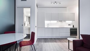 A modern kitchen with white cabinetry, a built-in oven, and a coffee machine. - La Perla By Sedar (Como)