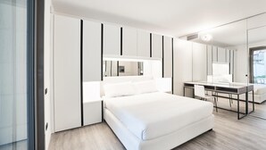 A modern bedroom with a bed, a desk, and a large mirror. - La Perla By Sedar (Como)