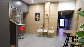 Um interior moderno com área de bar, assentos e obras de arte nas paredes.