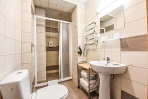 Un baño con inodoro, lavabo y zona de ducha.