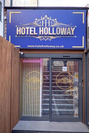 A hotel entrance with a blue sign reading 'HOTEL HOLLOWAY' and a website address. - Hotel Holloway (Birmingham)