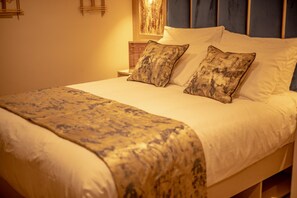 A neatly made bed with a patterned bedspread, pillows, and a headboard. - Hotel Holloway (Birmingham)