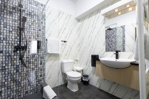 A modern bathroom with a glass shower enclosure, a white toilet, a sink with a mirror above it, and a marble-patterned wall. - Apart Hotel Bonjour Cluj (Cluj-Napoca)