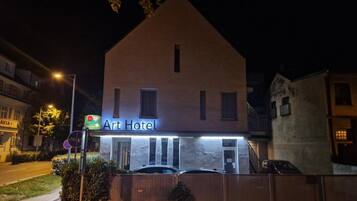 A two-story building with a sign reading 'Art Hotel' at the entrance.