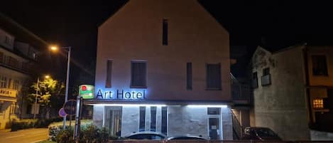 A two-story building with a sign reading 'Art Hotel' at the entrance.