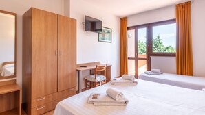 A hotel room with two beds, a desk, a chair, a wardrobe, and a TV. - Hotel La Carica (Pastrengo)