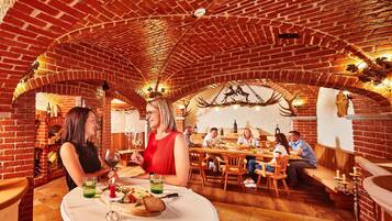 A restaurant with brick arches, wooden tables, and a variety of seating options.