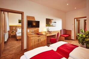 A hotel room with a bed, desk, and seating area. - Donauhotel Lettnerhof (Naarn im Machlande)
