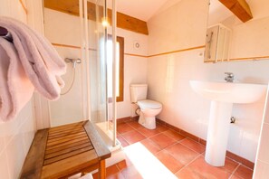 A bathroom with a wooden bench, a glass shower enclosure, a toilet, and a sink. - Casa Vecchia Rooms Apartments (Calvi)
